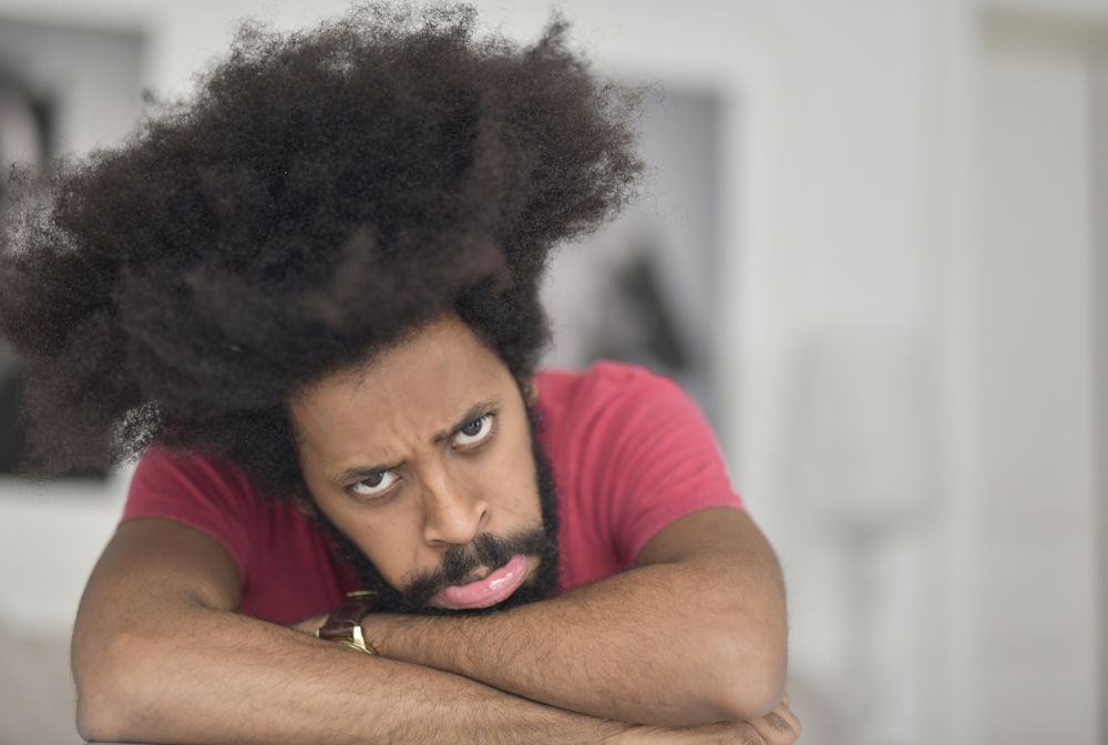 man with dense natural afro curls in a close portrait