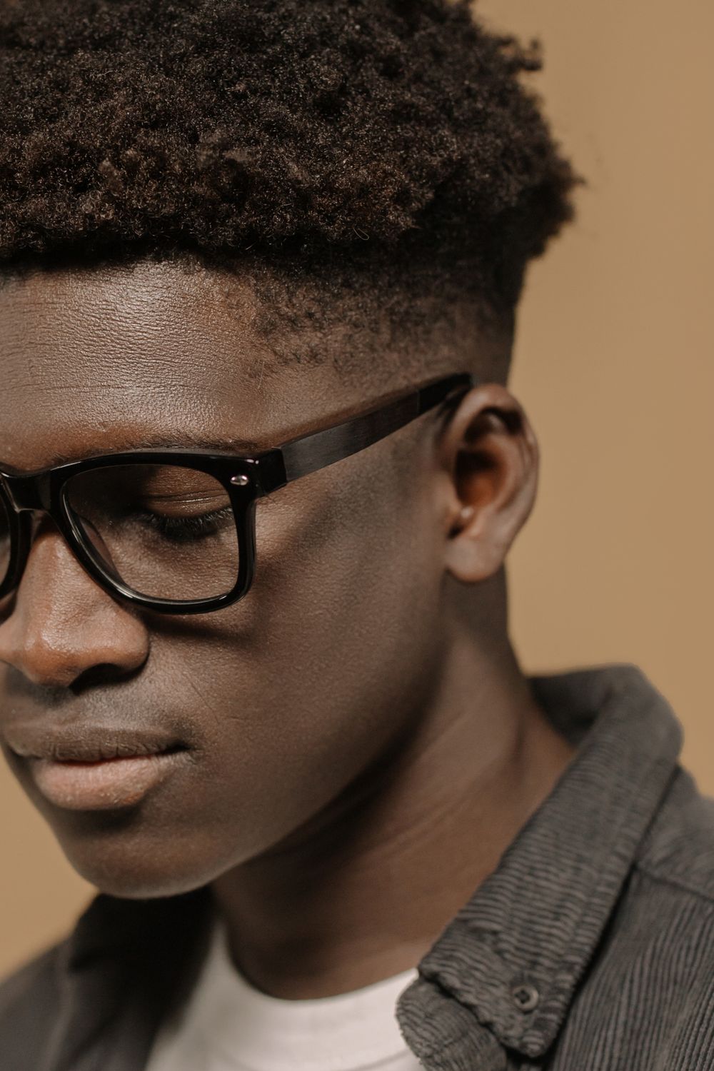man wearing glasses with a short afro and temple taper