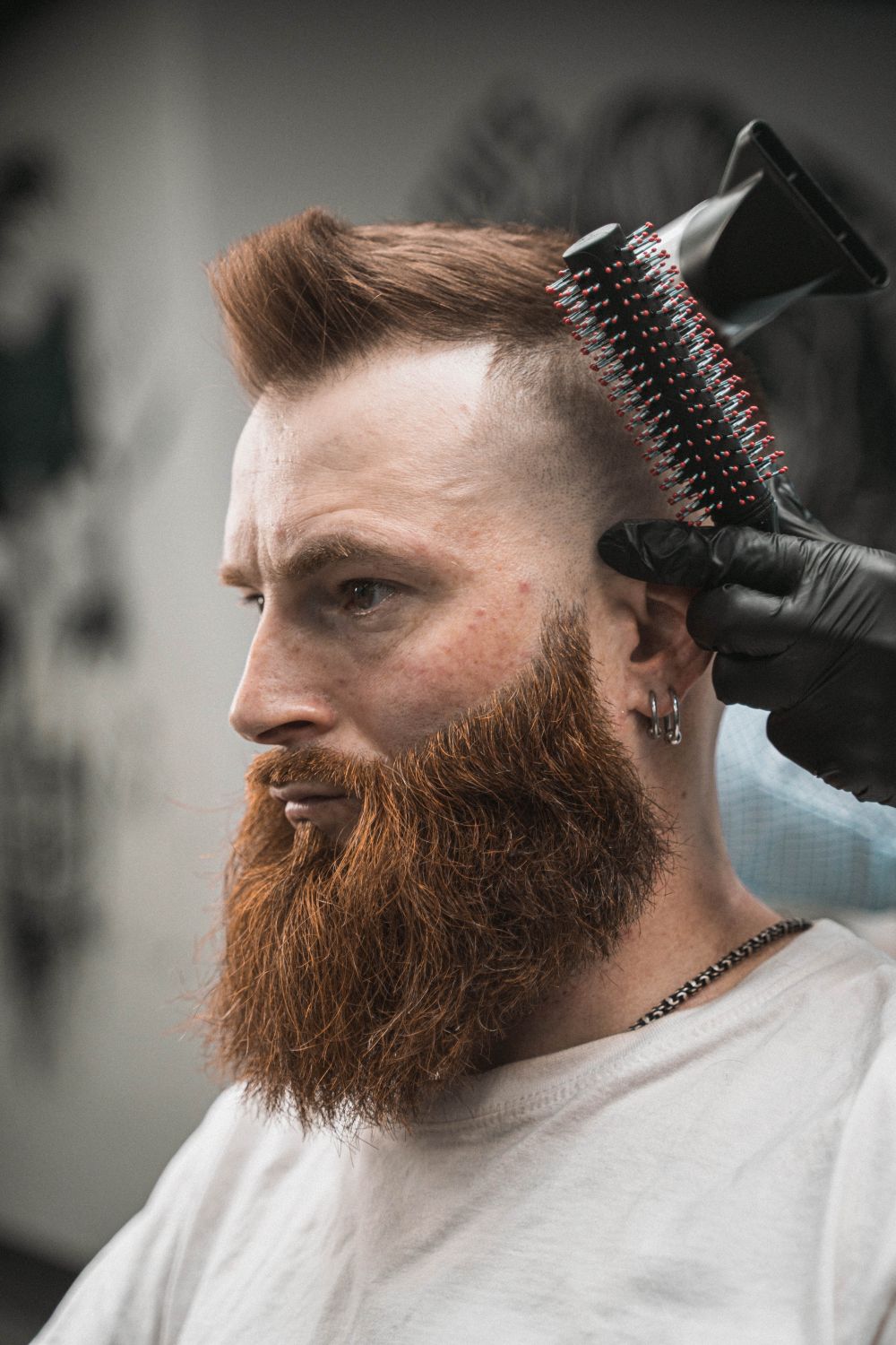 bearded man getting a tapered haircut in a barbershop