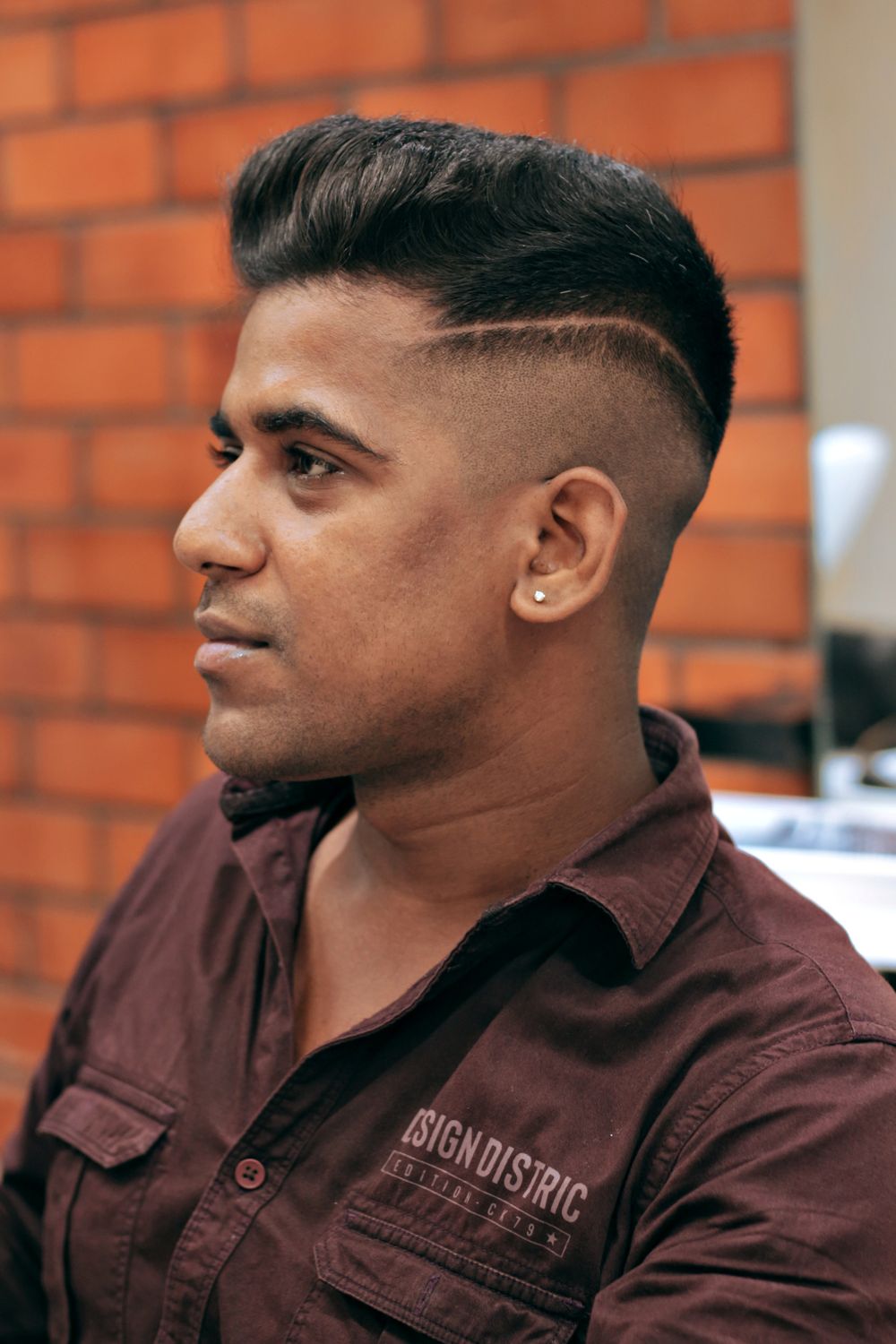 man in barbershop with comb over fade hairstyle