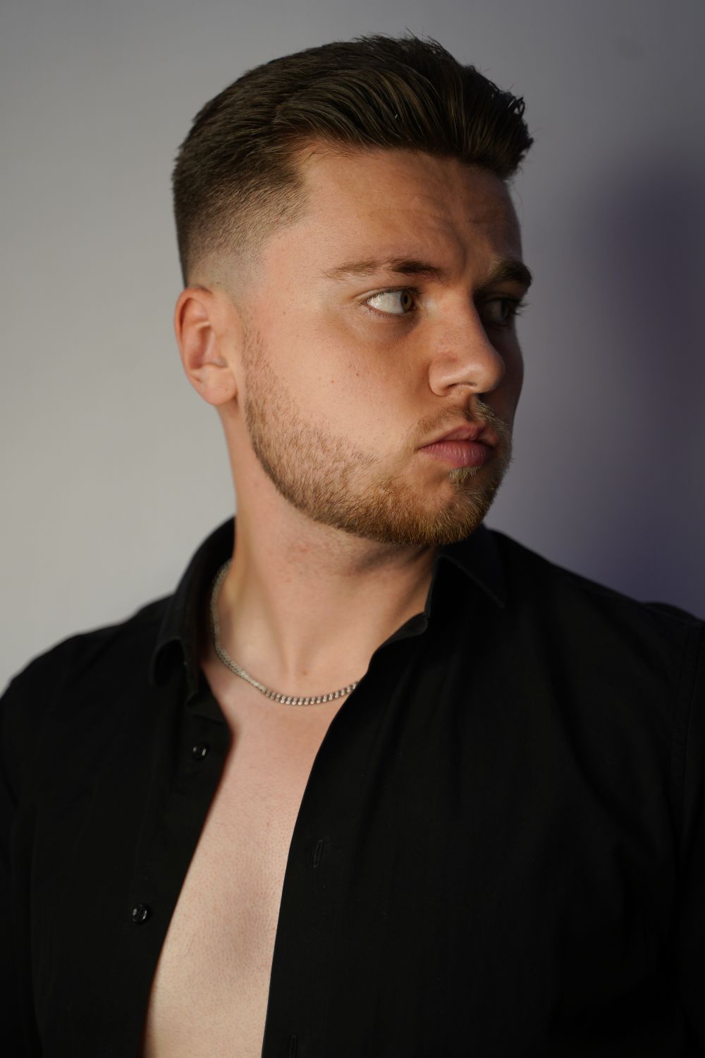 side profile of man with a short taper haircut and trimmed beard