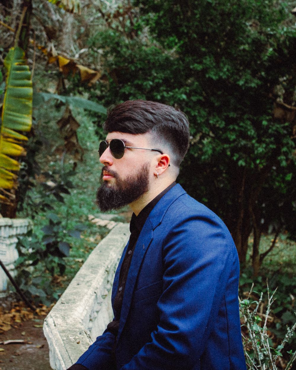bearded man with side part hairstyle and tapered sides