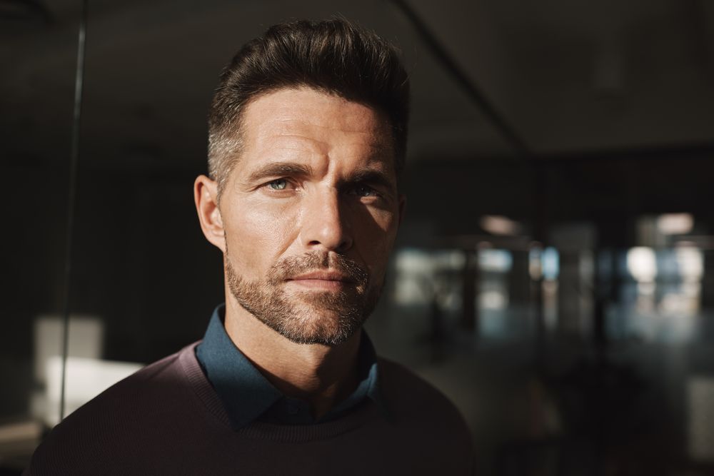 bearded man with short brushed back hair in an office-ready look