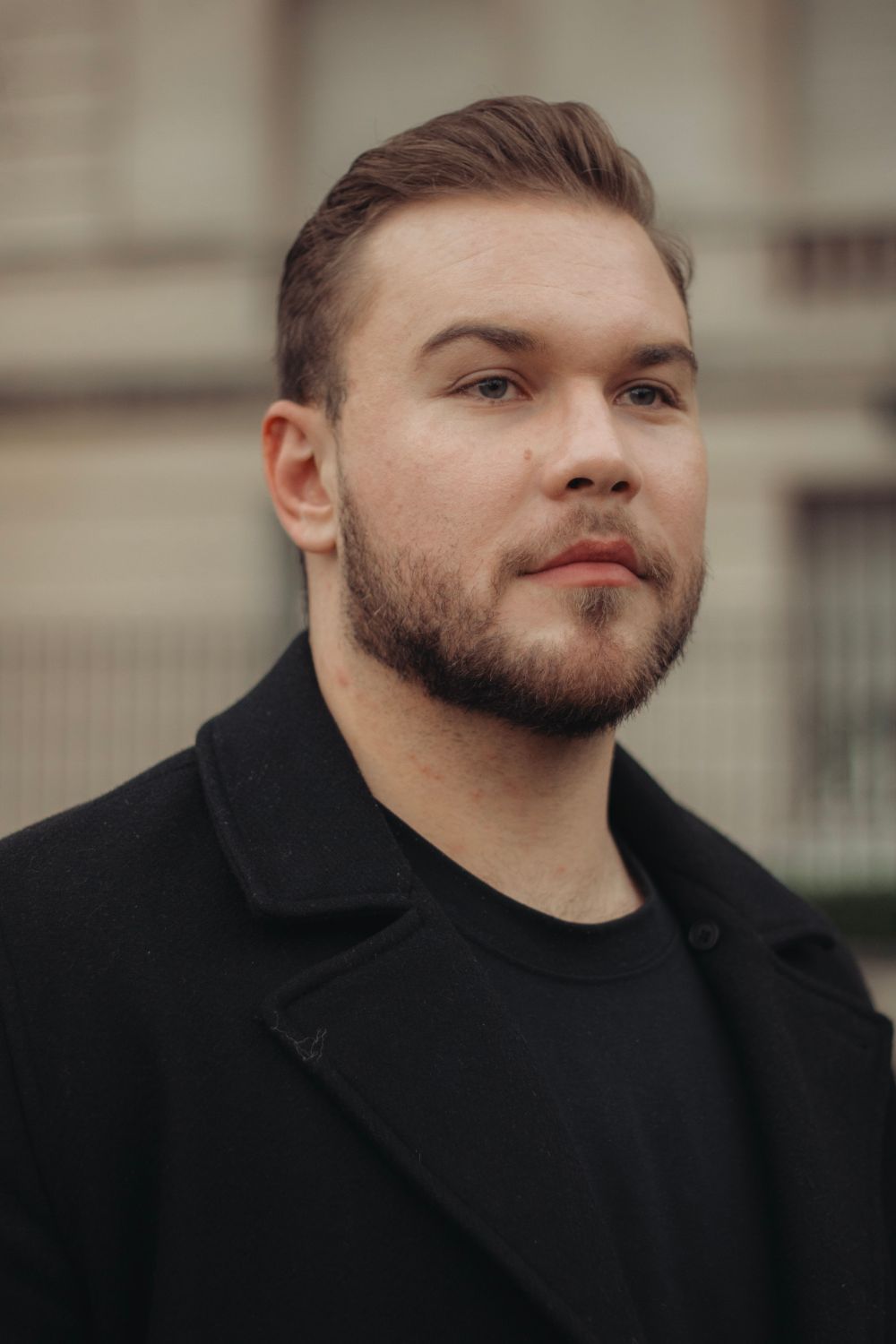 man with a brushed back short taper hairstyle and beard