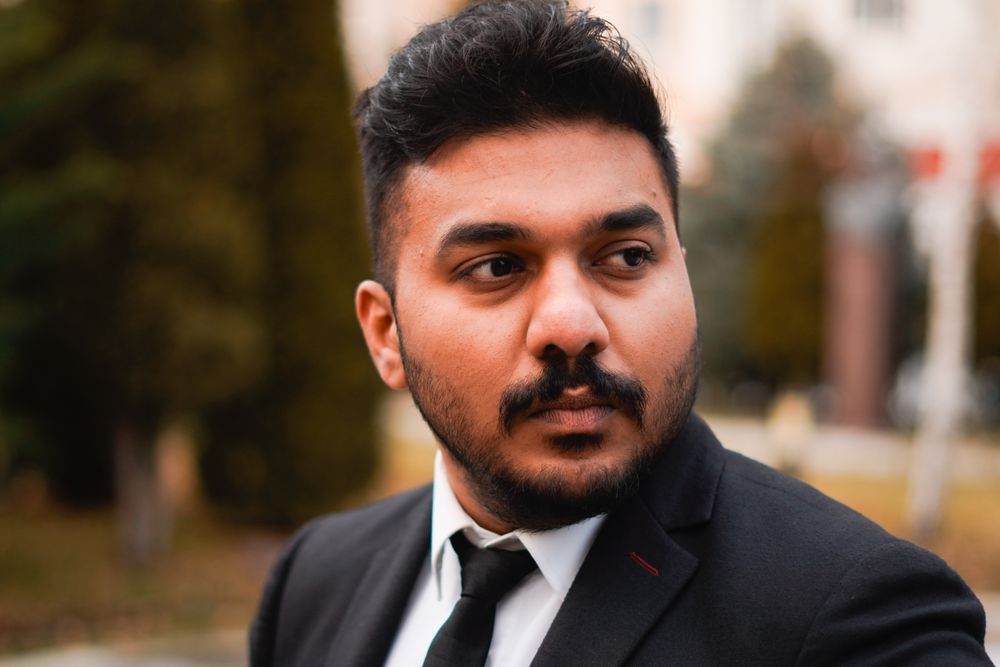 man with short textured professional haircut in a black suit