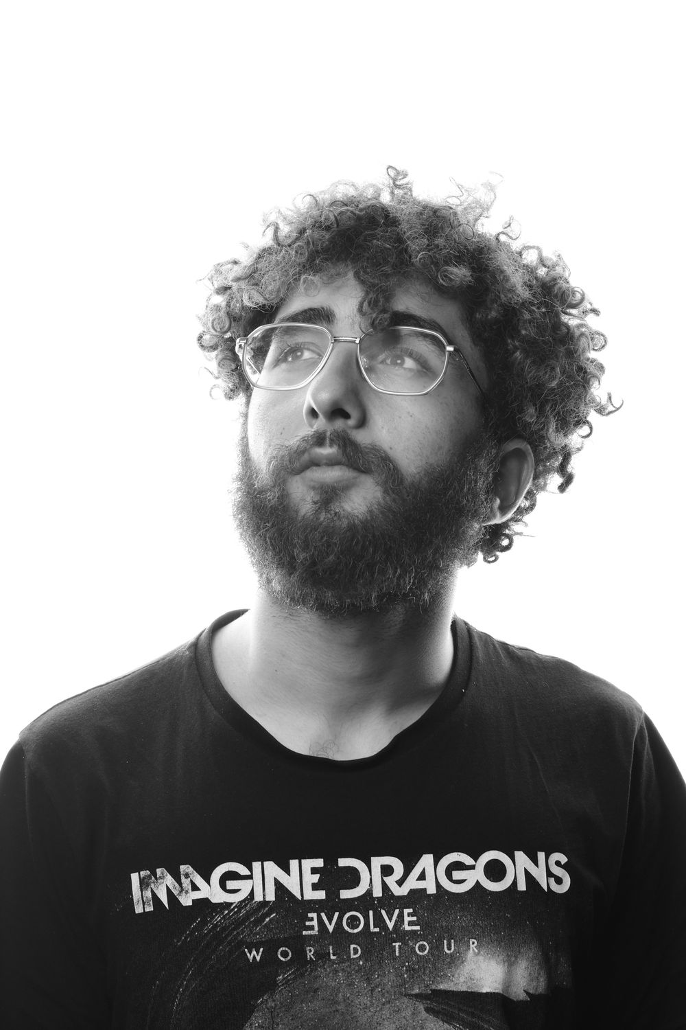bearded man wearing glasses with medium curly hair volume