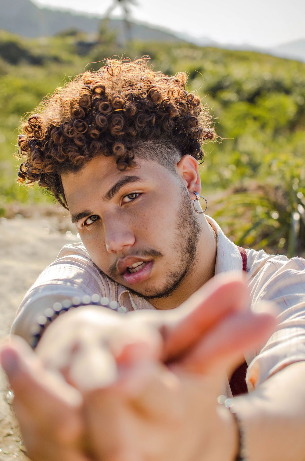 man with a short curly crop and low faded sides outdoors