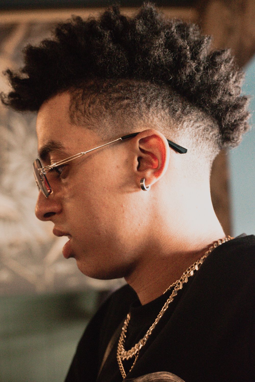 side profile of man with curly top, low fade and sunglasses