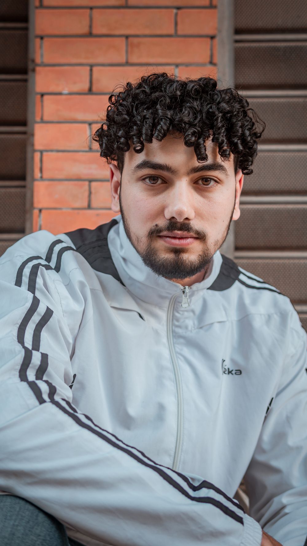 man with a short curly top and clean tapered outline