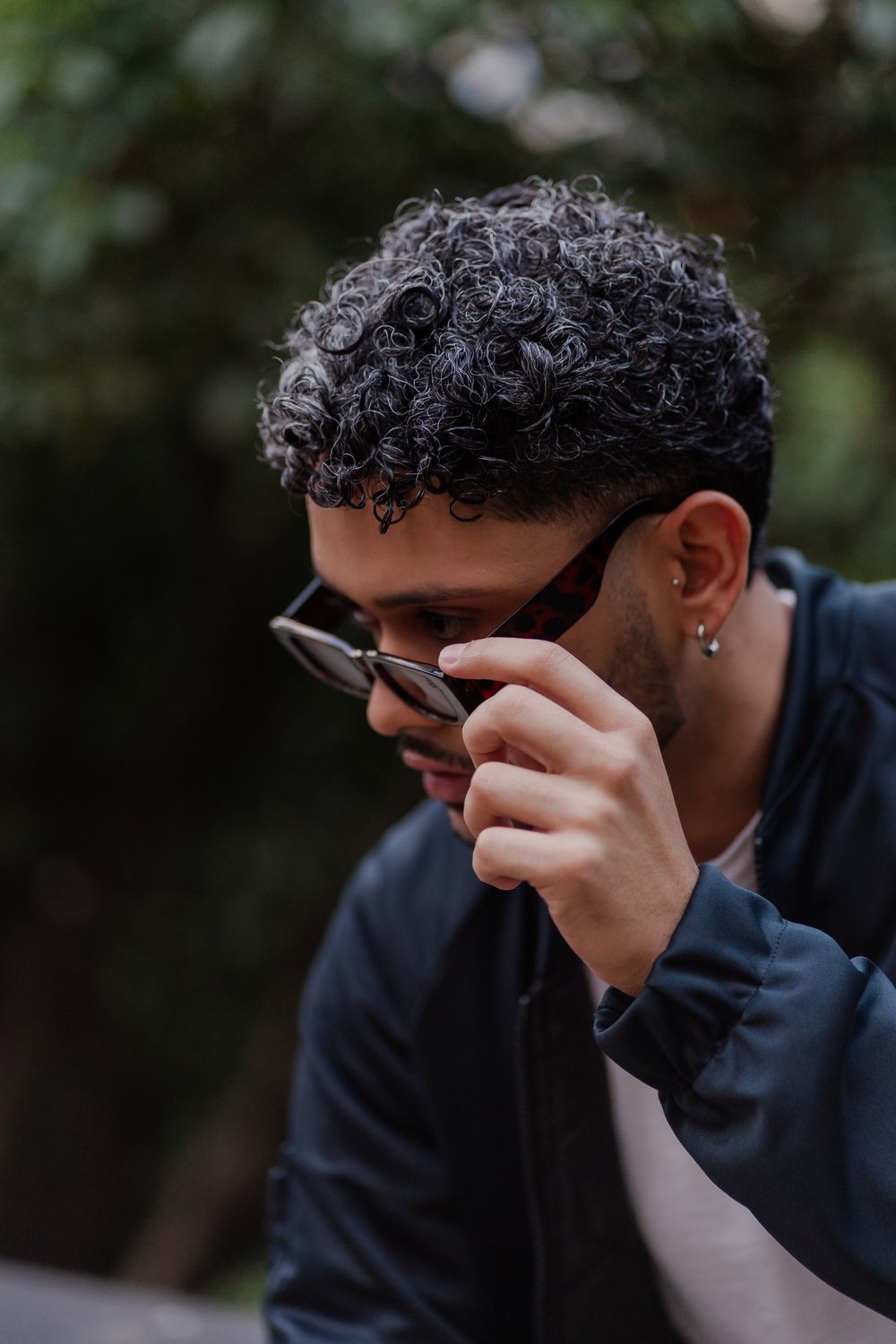 man wearing sunglasses with a short curly taper haircut