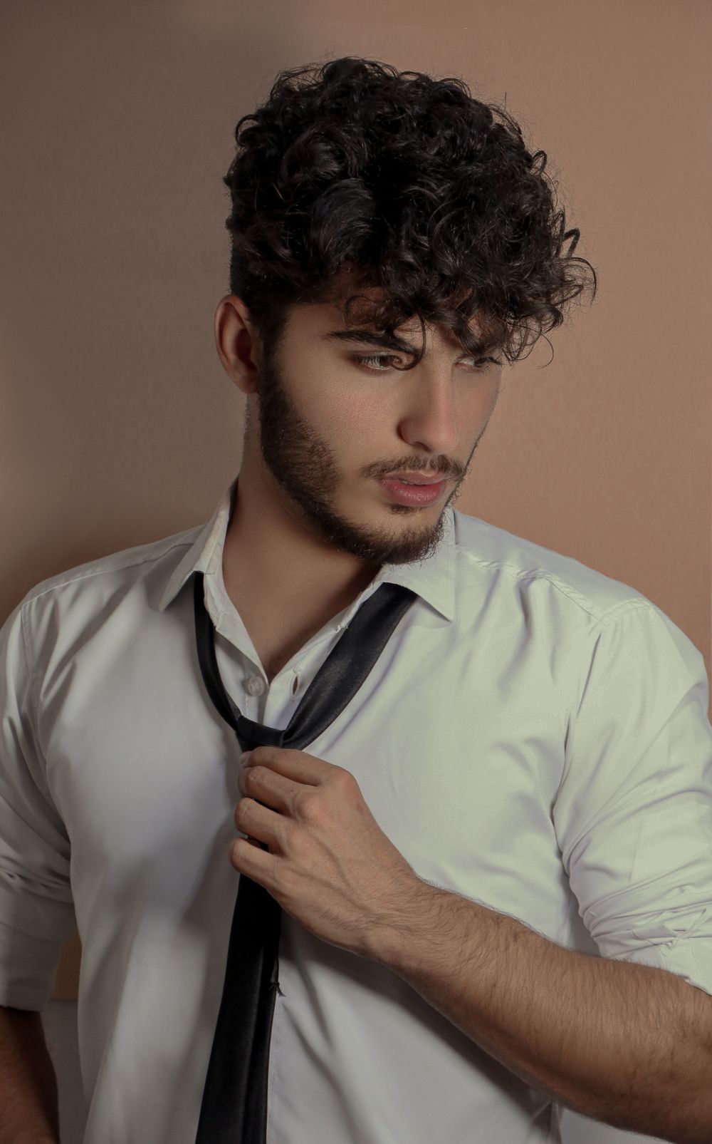 man with medium curly hairstyle and soft front volume