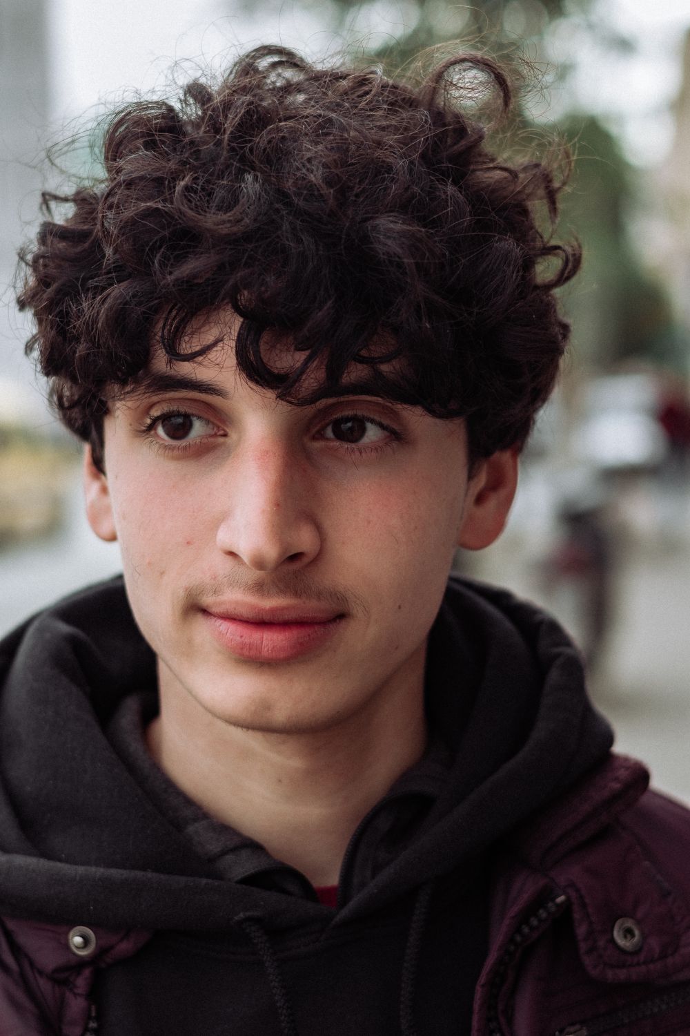 young man with dark curly fringe hairstyle