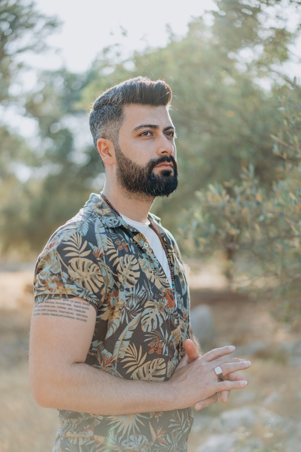 bearded man with short wavy hair and a soft tapered profile