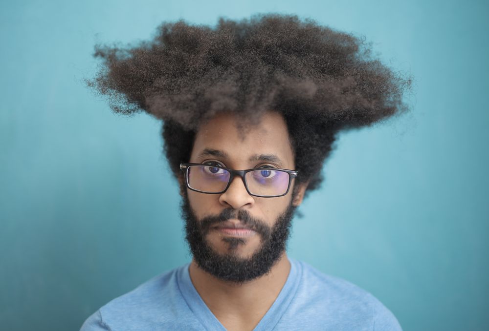 man with full afro hairstyle wearing glasses
