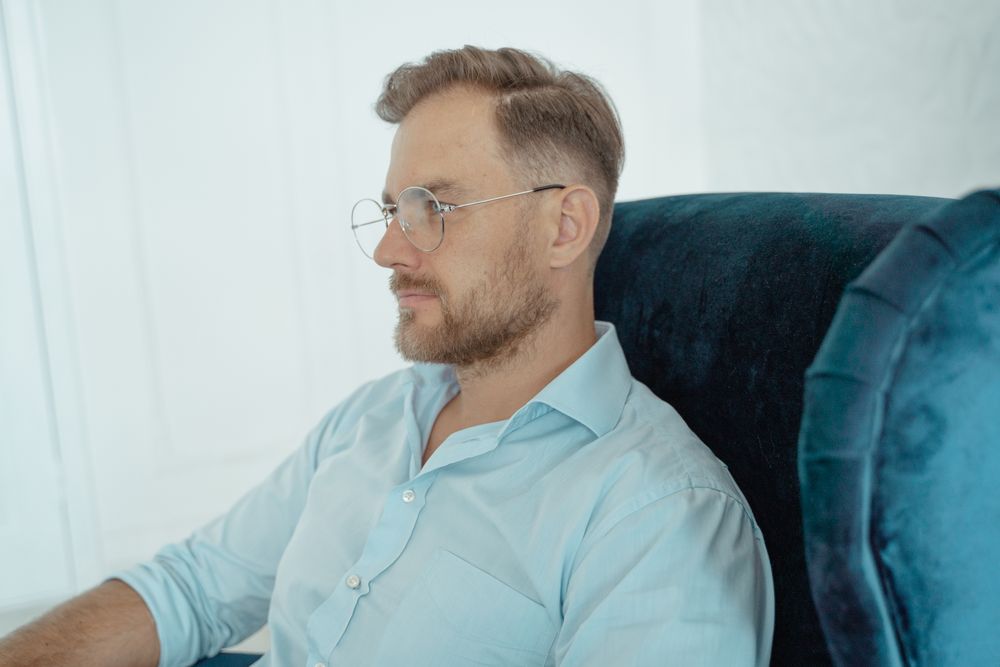 bearded man wearing glasses with medium side swept hair
