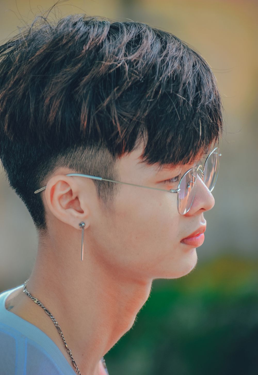 side profile of man with glasses and a clean short fade