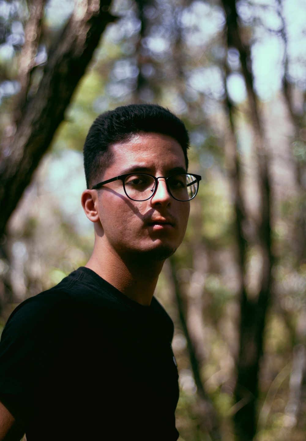 man wearing glasses with short curly high top hairstyle