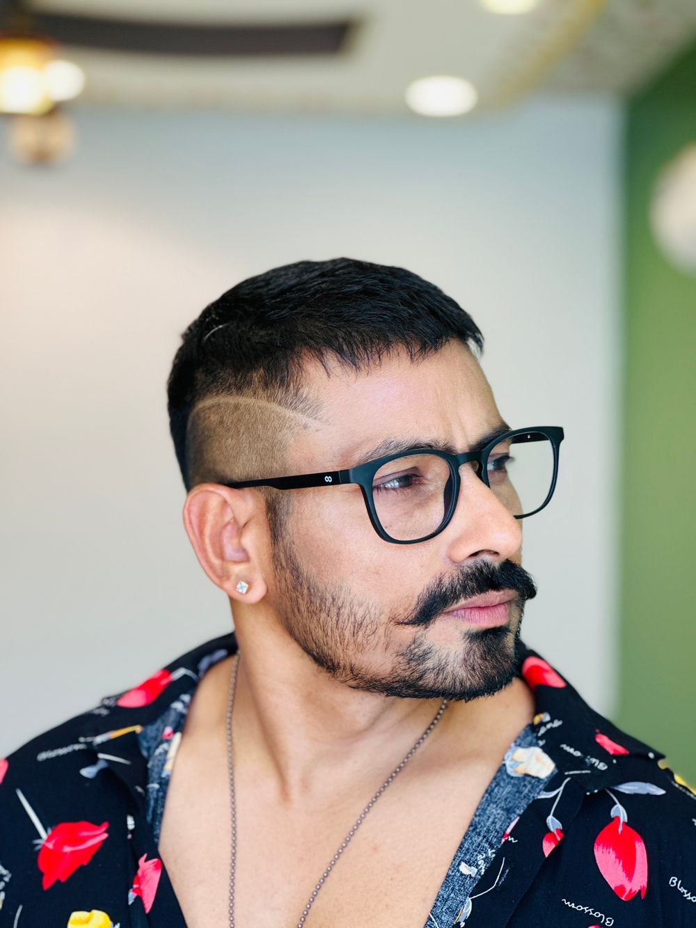 bearded man wearing glasses with a textured pompadour haircut