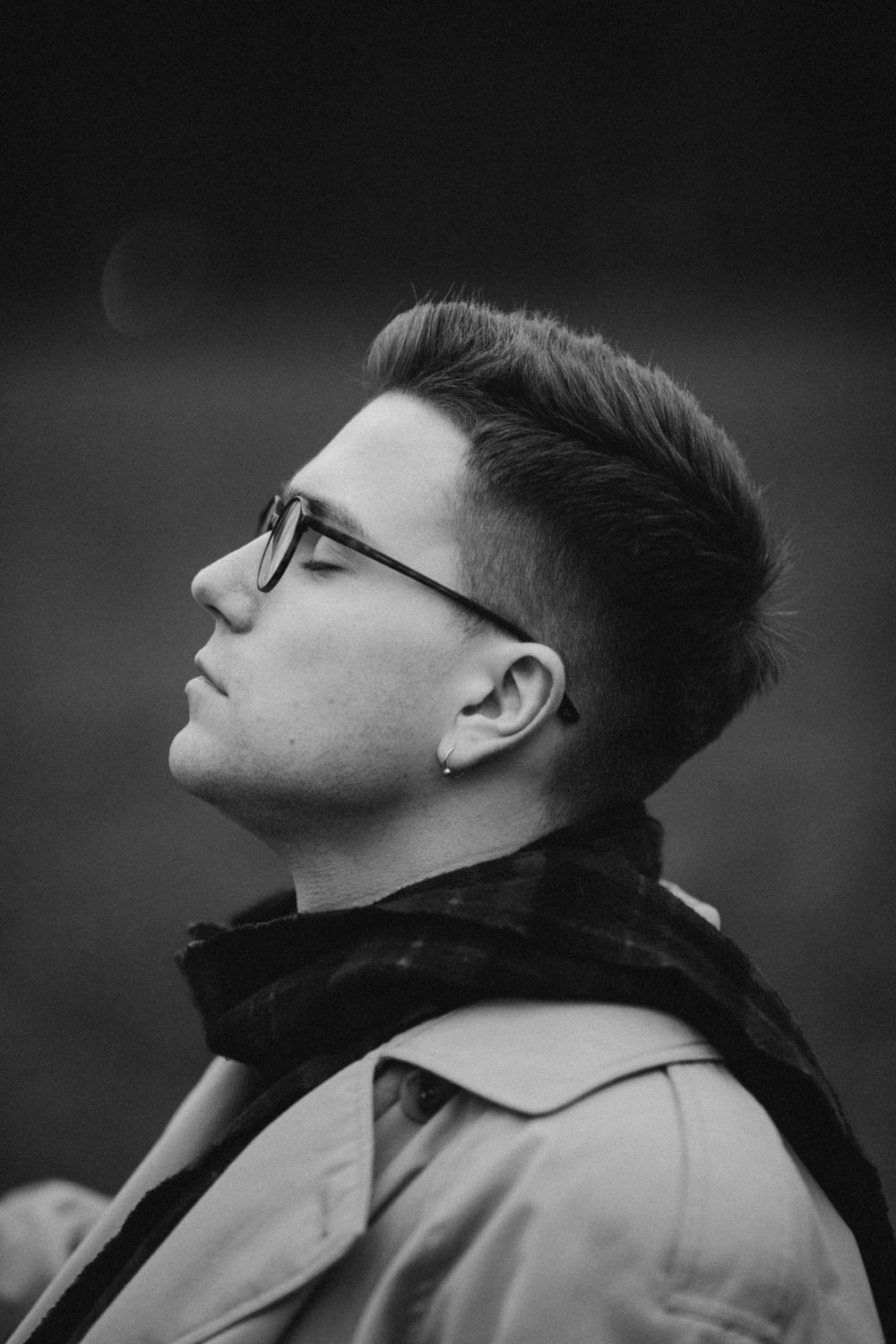 man wearing glasses with a short pompadour and tapered sides