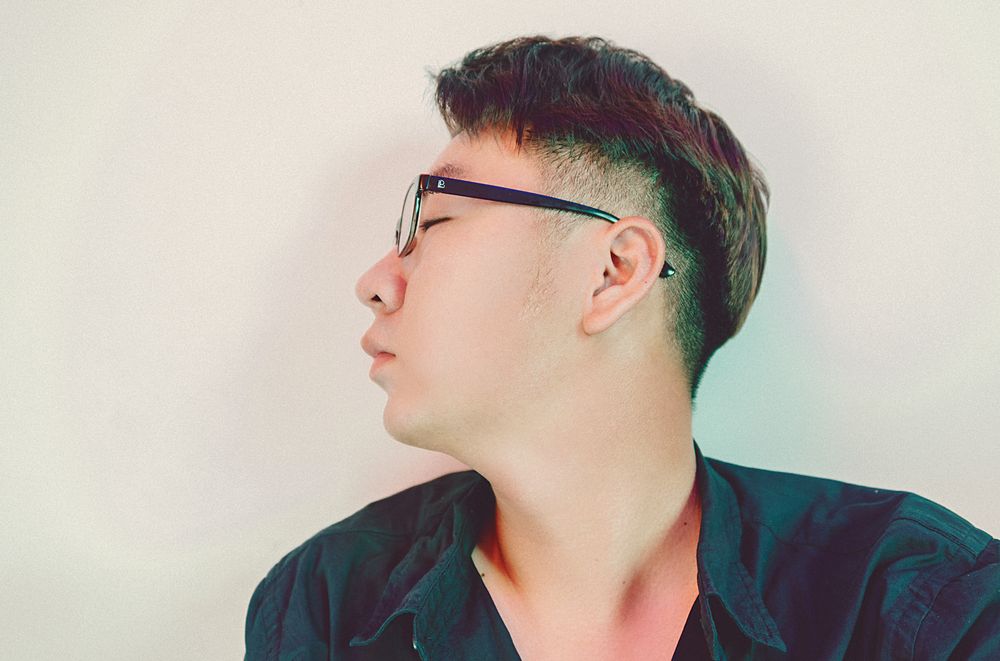 side profile of man wearing glasses with a short tapered haircut