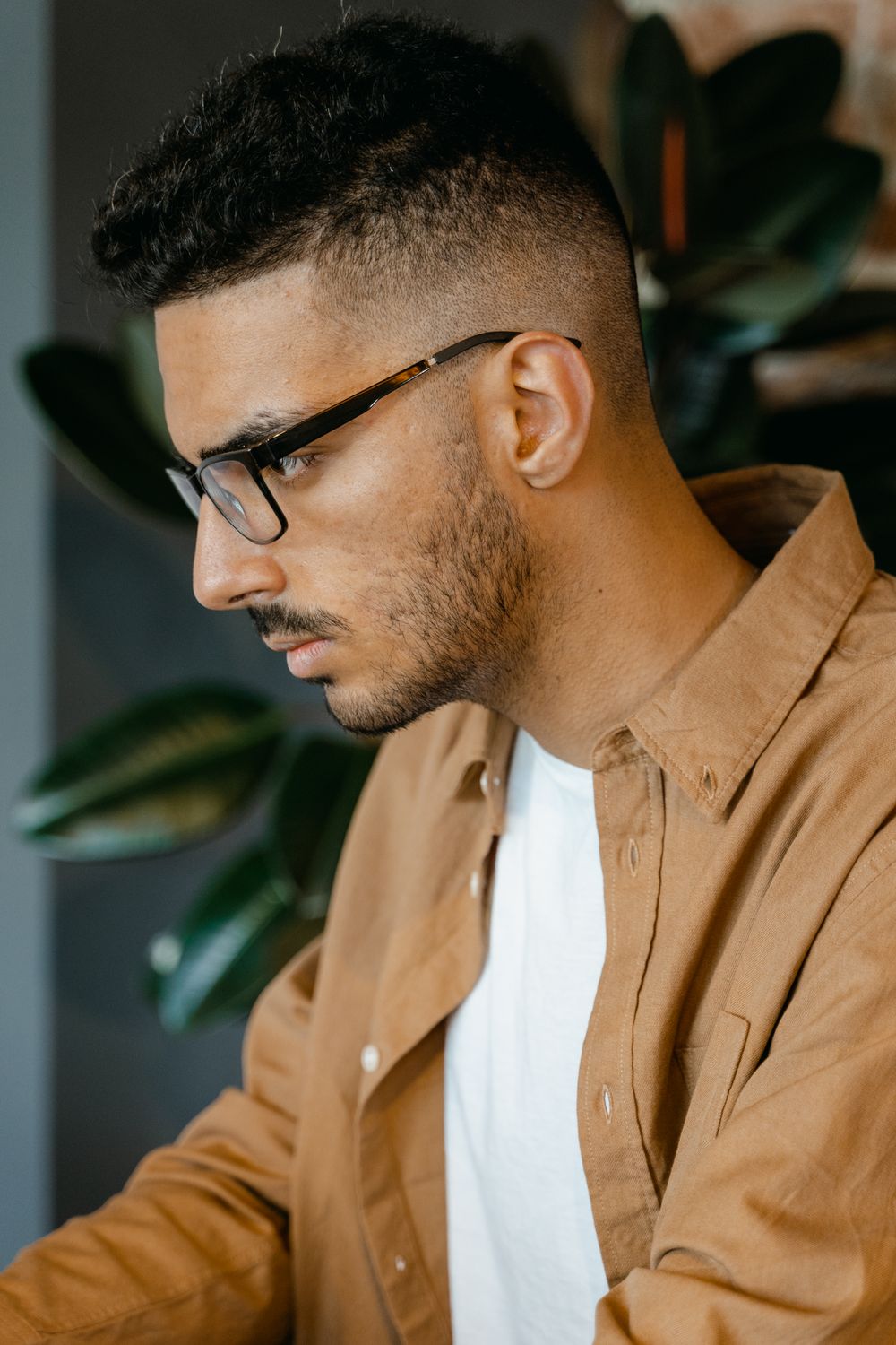 side profile of man wearing glasses with a short tapered haircut