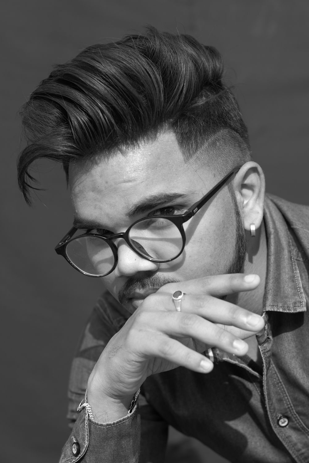 man wearing glasses with a short textured quiff hairstyle