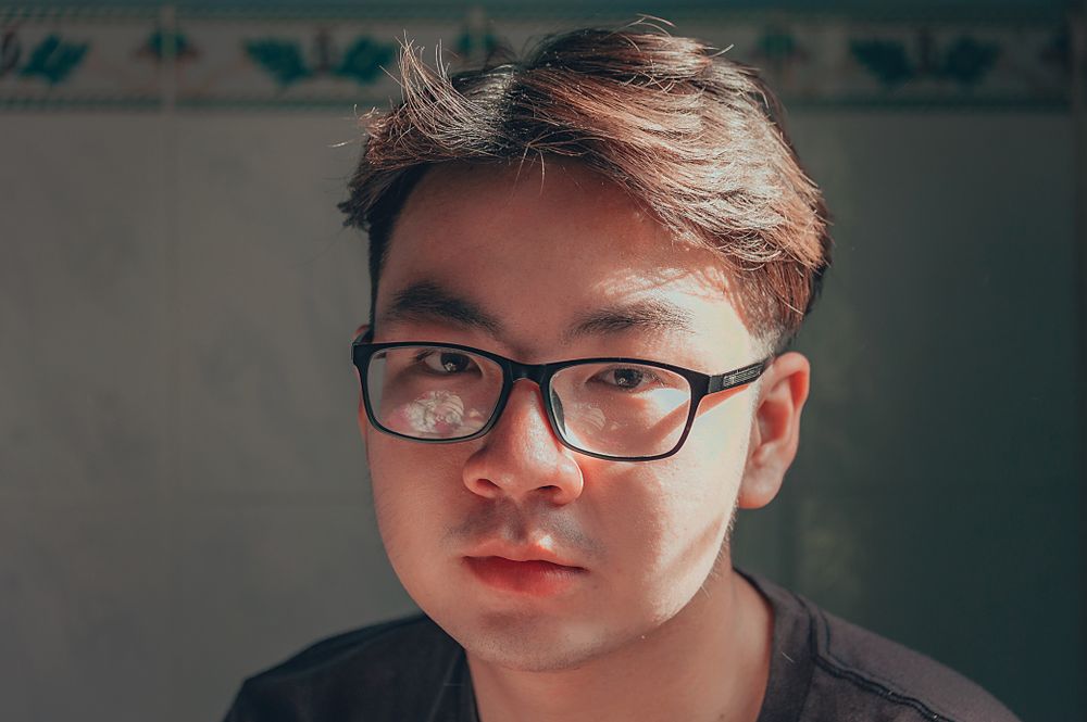 man wearing glasses with a short wavy textured crop