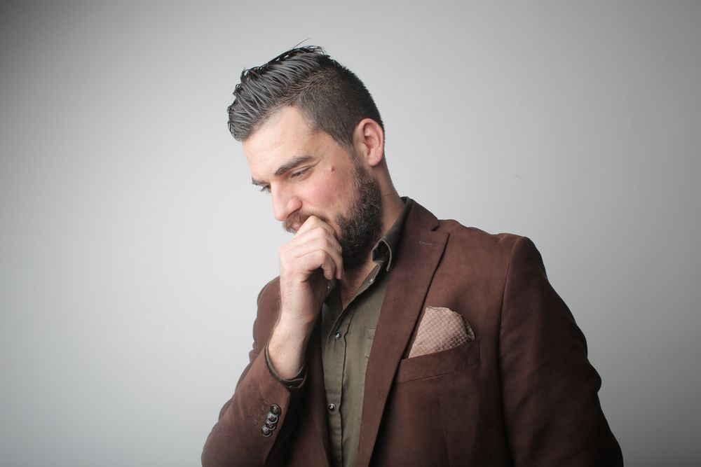 older man with gray side part and beard