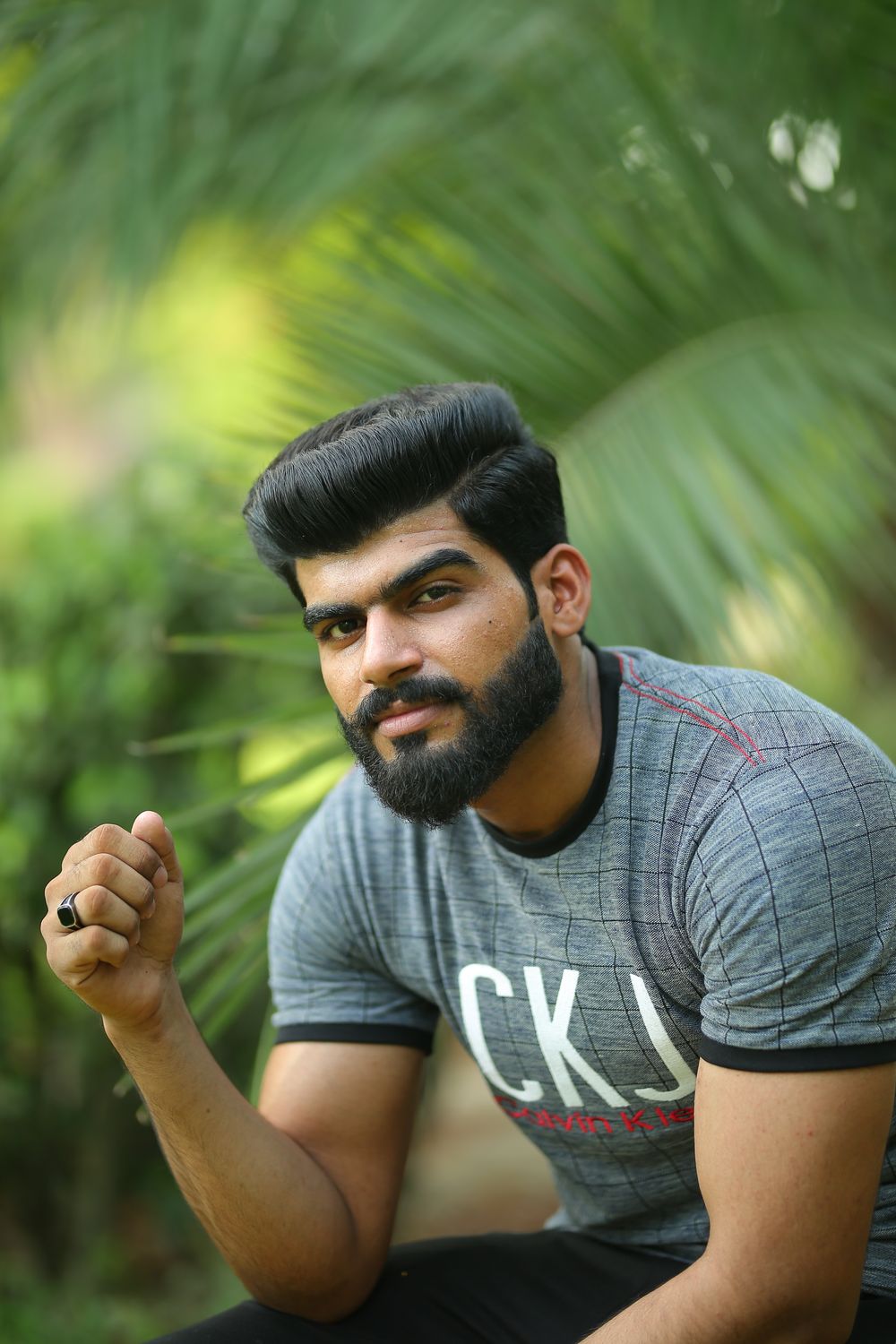 man with a high volume side part hairstyle and neat beard