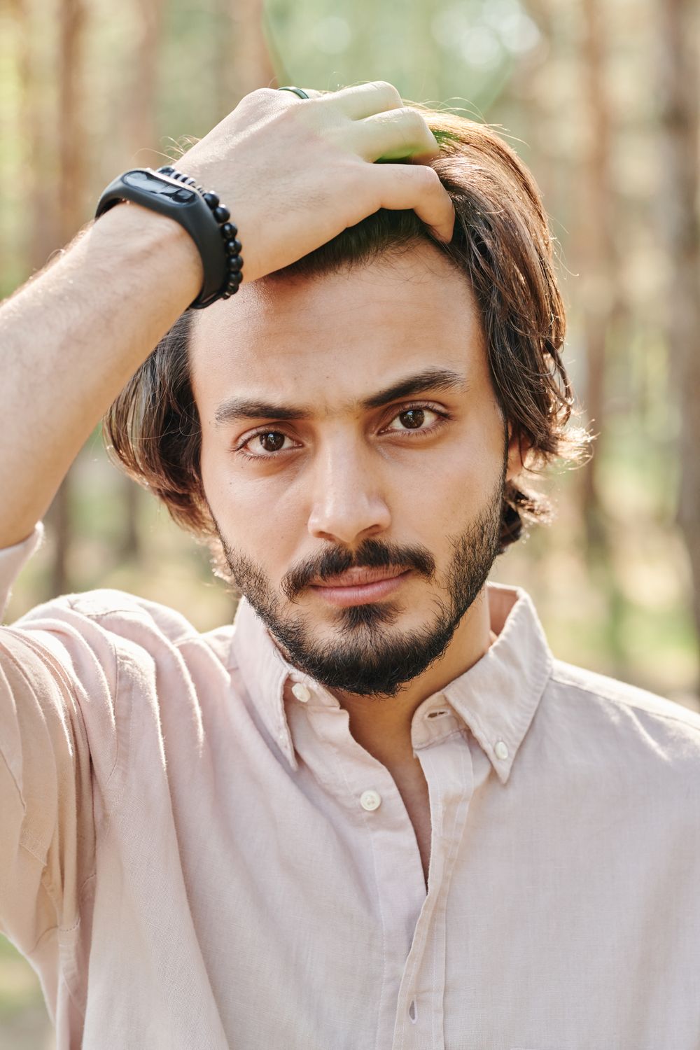 man with medium wavy hair brushed back and a short beard