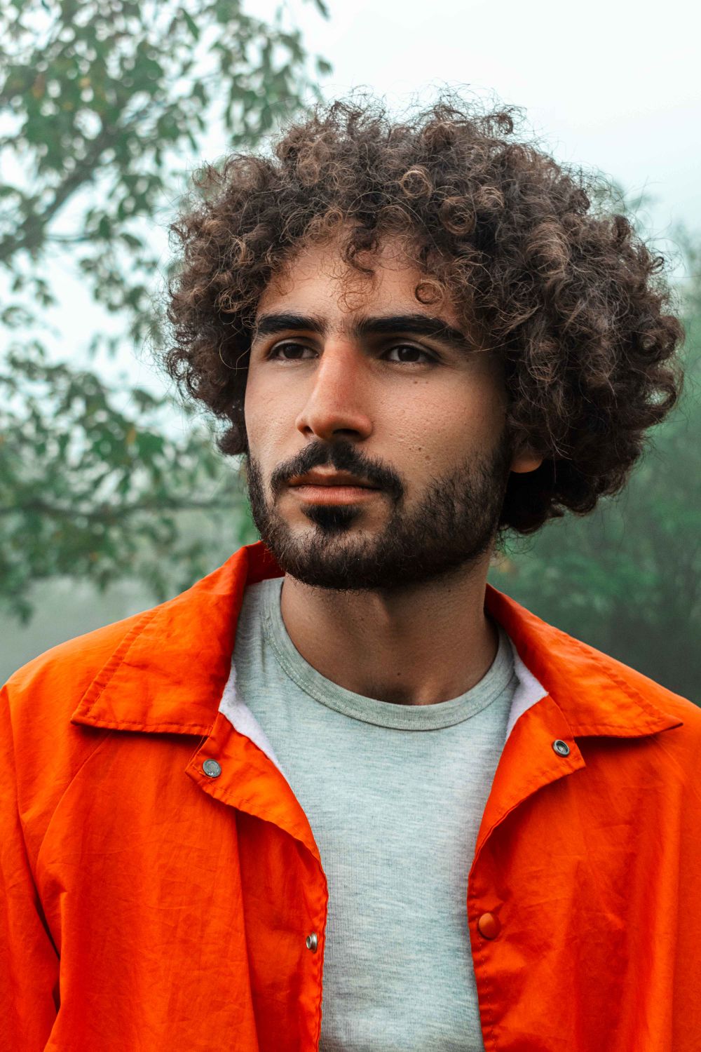 man with loose medium curly hairstyle and natural volume