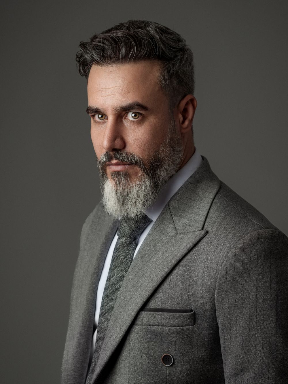 mature man with beard and classic side part hairstyle in a suit
