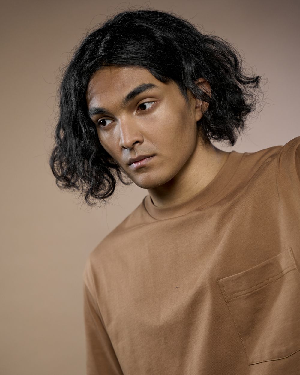 man with medium wavy dark hair and natural texture