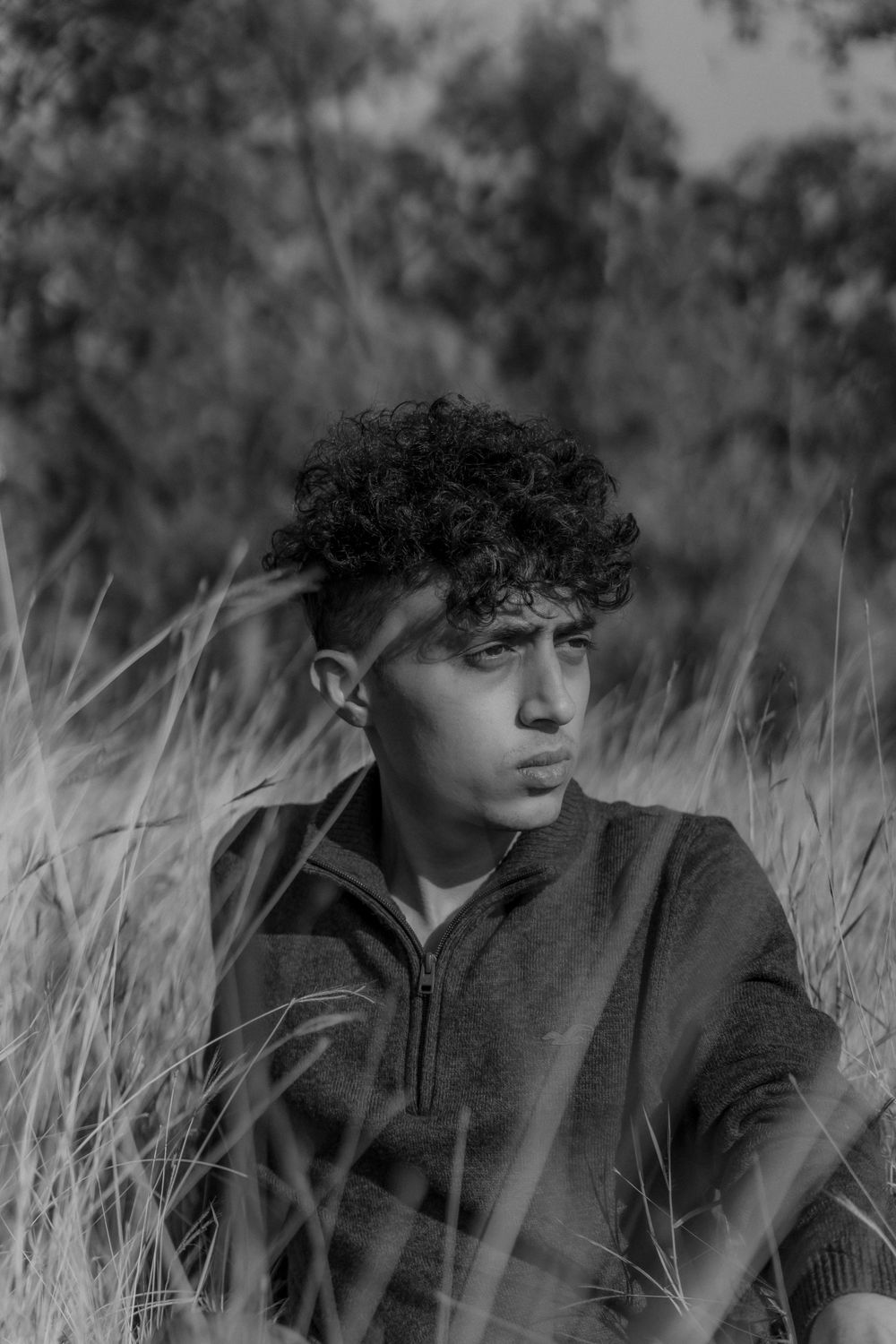 man with soft medium length curly hair in a black and white portrait