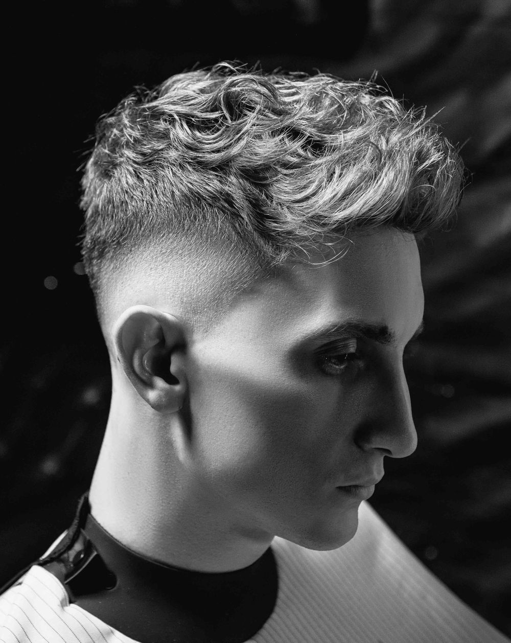 side profile of man with a textured wavy top and taper