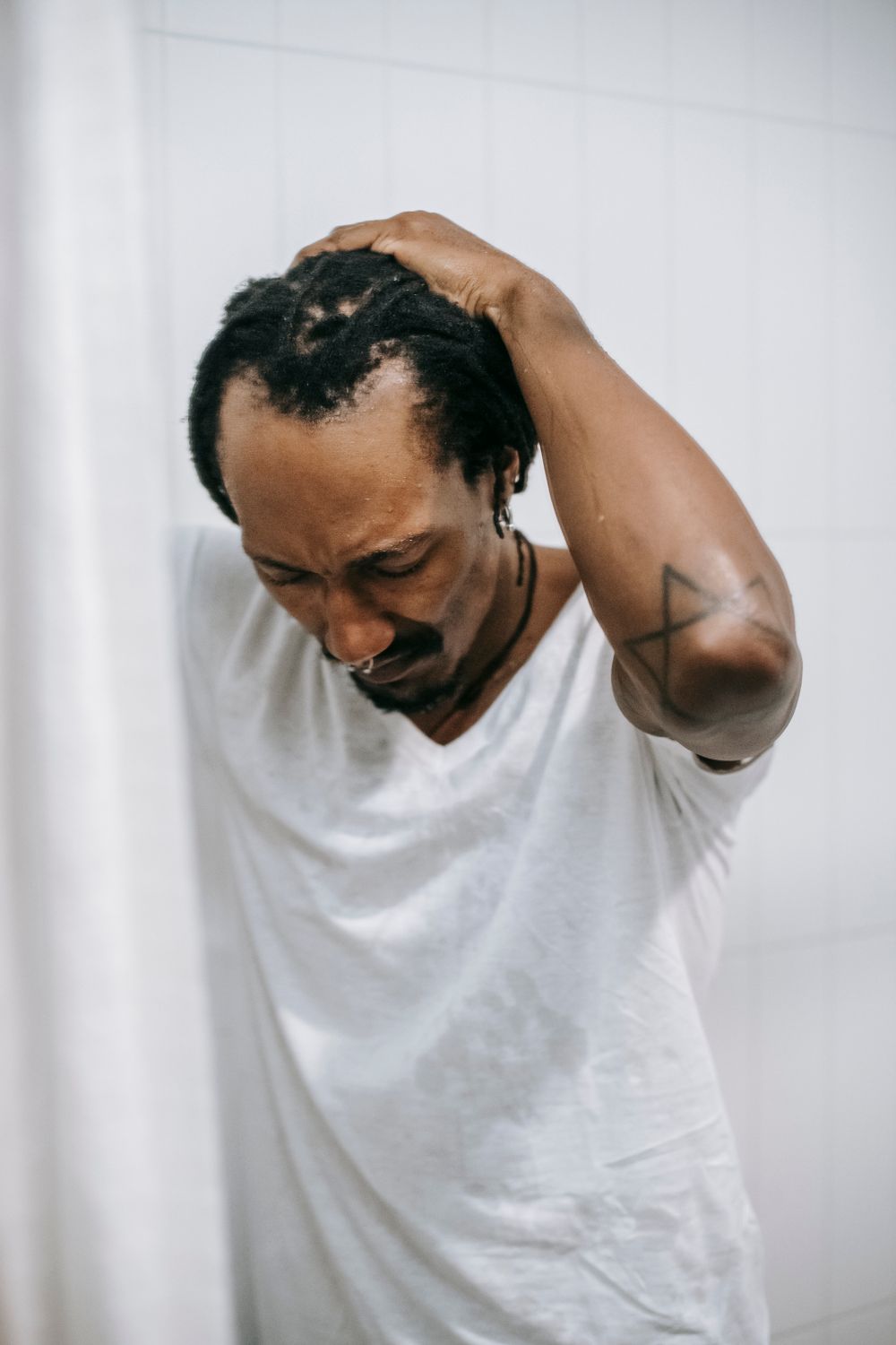 man with short natural locs and a high hairline