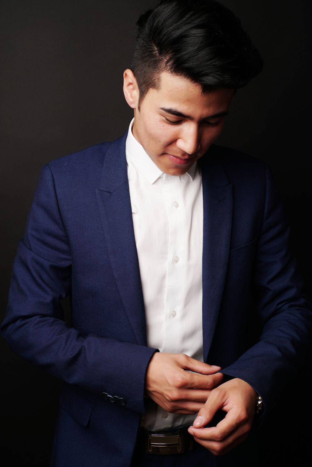 man in navy suit with a clean short side part hairstyle