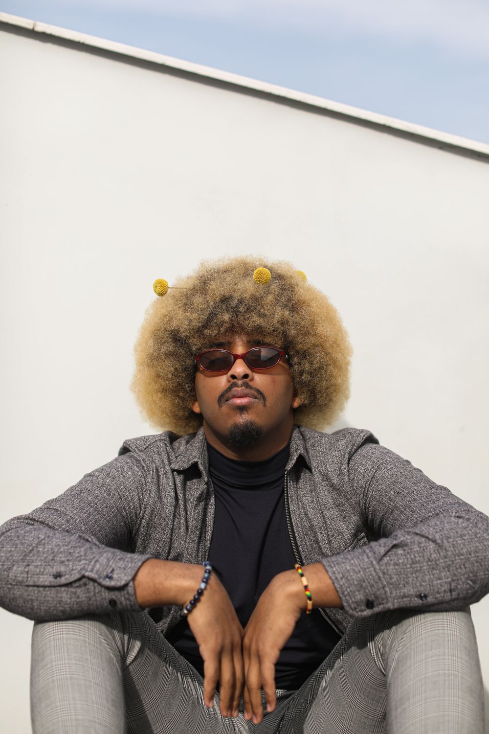 man wearing glasses with a large rounded afro hairstyle