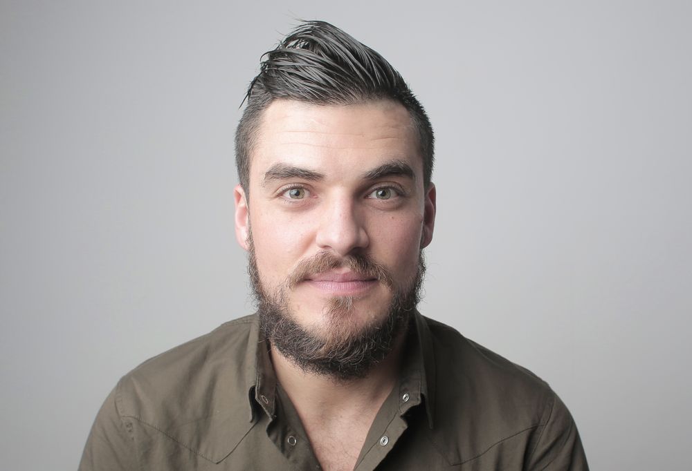 bearded man with a polished short side part hairstyle