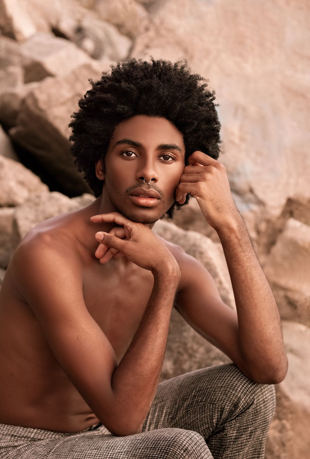 man with a rounded medium afro hairstyle in a studio portrait