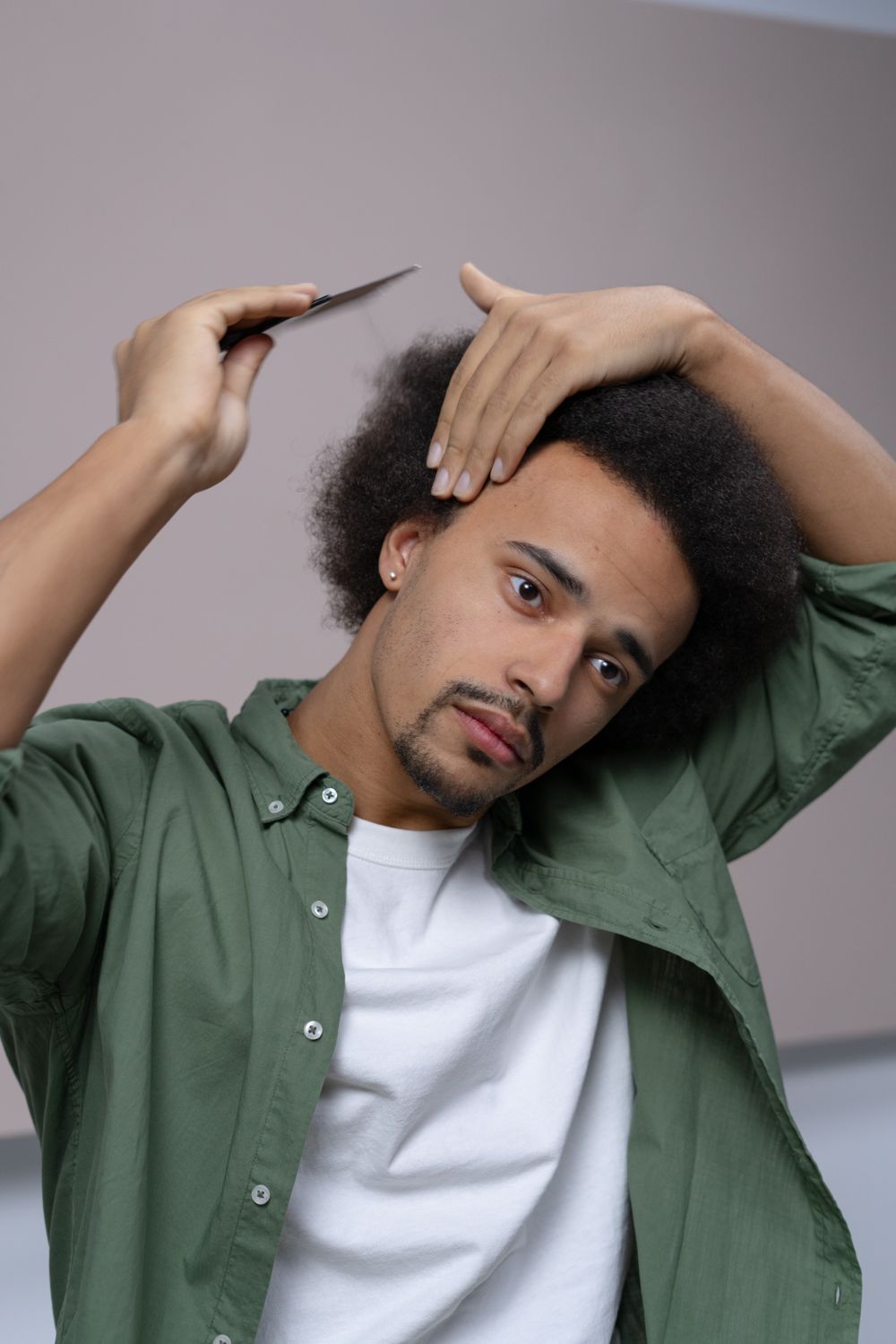 man shaping medium afro hairstyle with hands