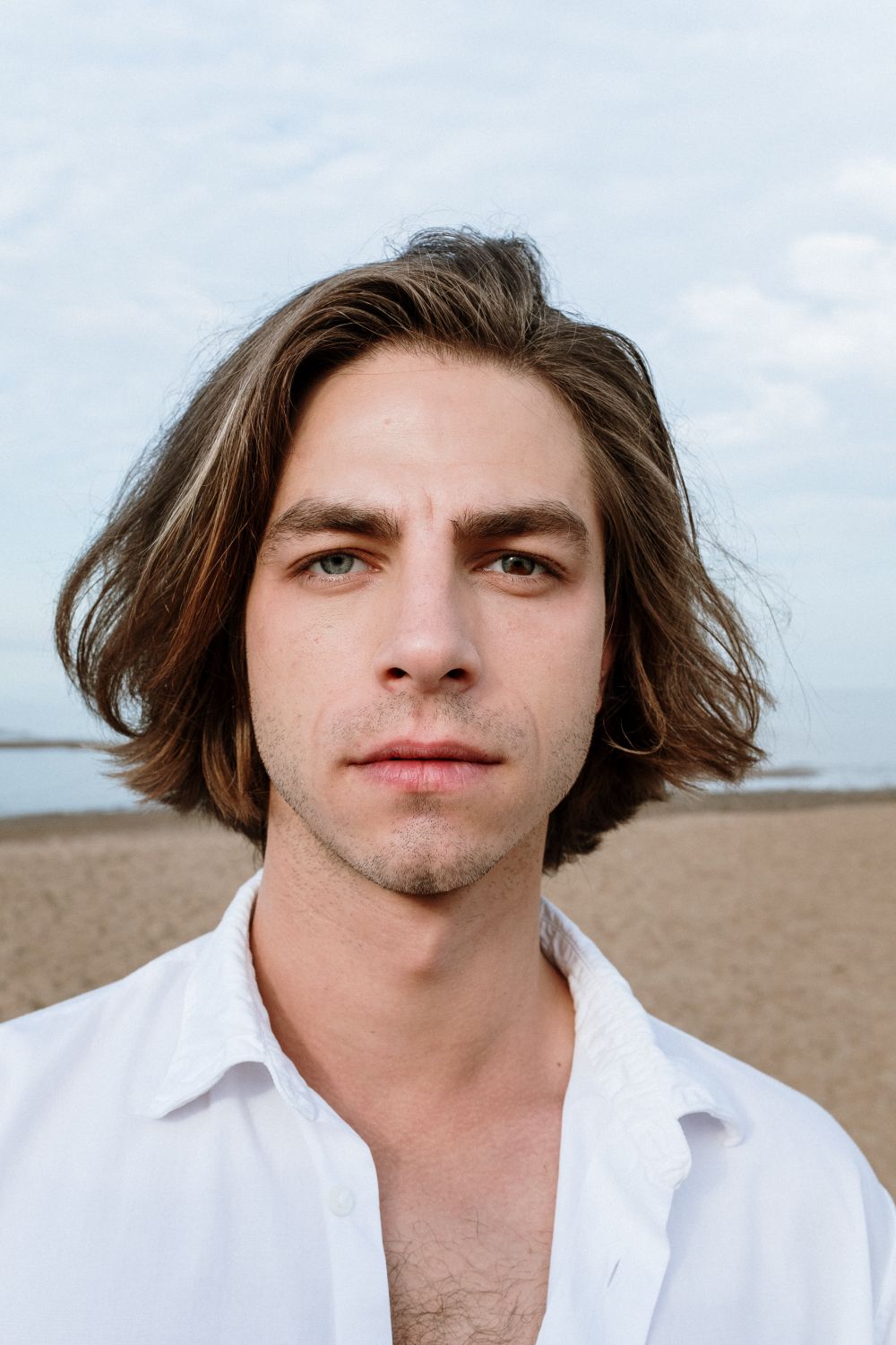 man with shoulder length wavy hair and soft layers