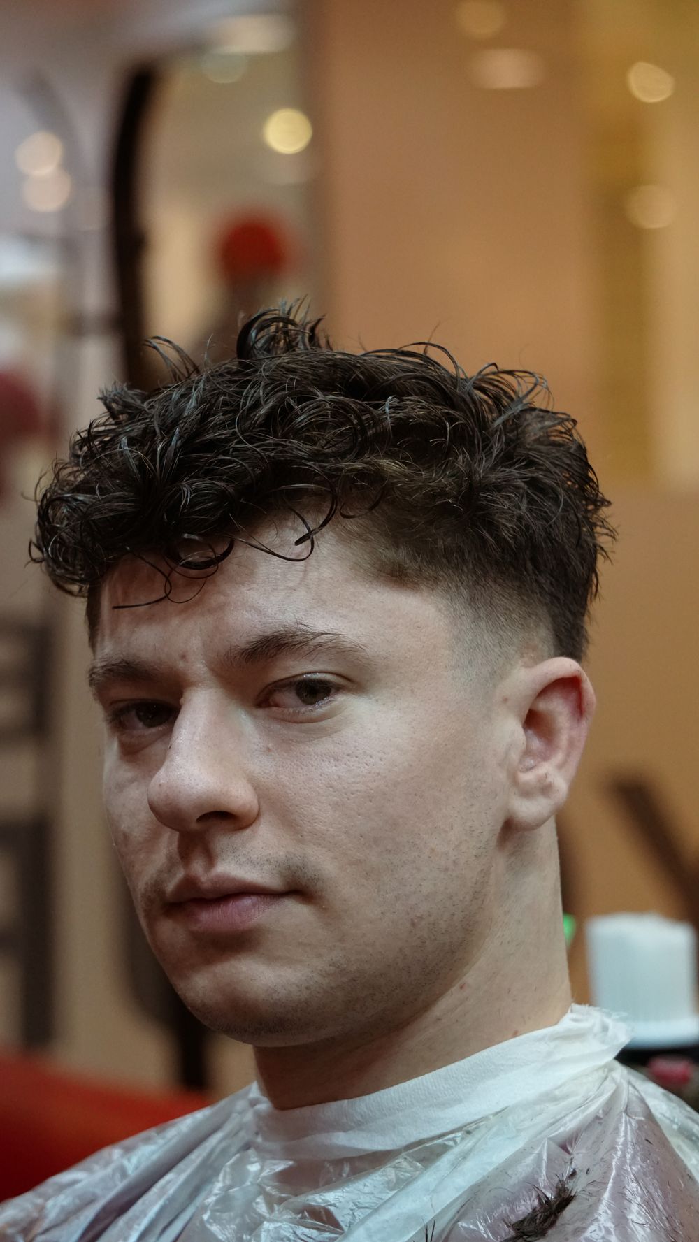 man with a soft curly crop and tapered faded sides