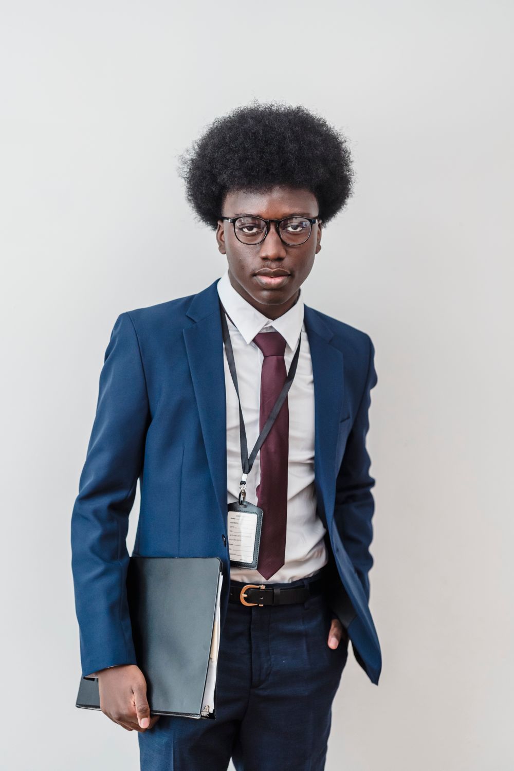 man wearing glasses with a rounded afro hairstyle and blue suit