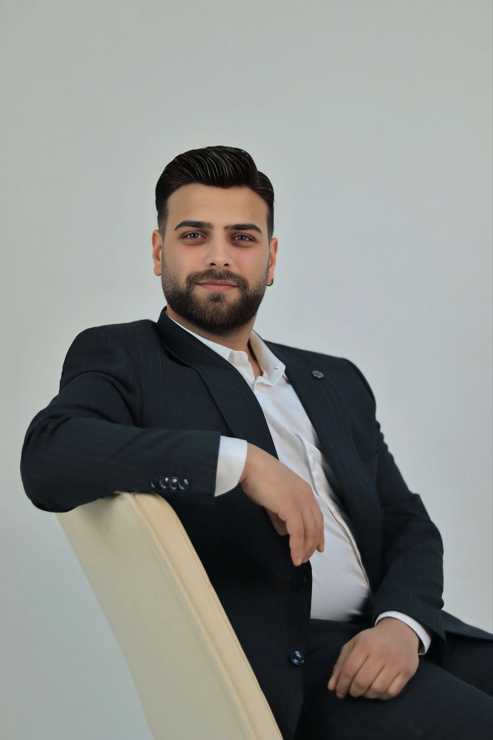 man in a suit with a polished side part and short beard