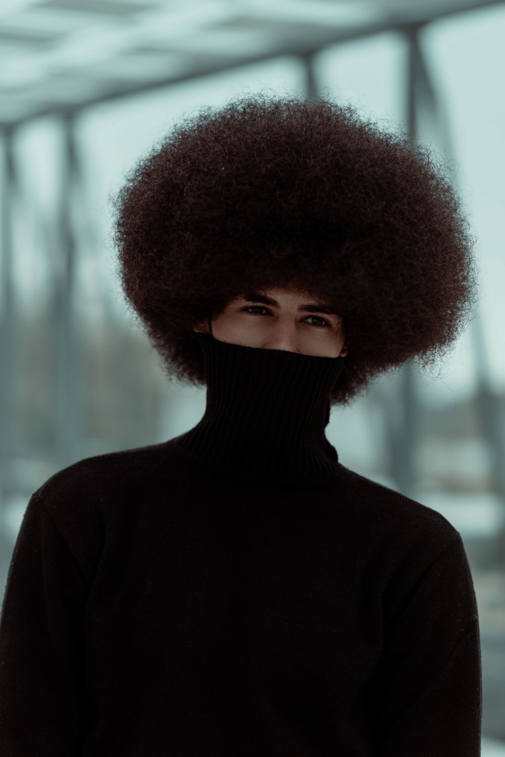 man with a full afro hairstyle wearing a dark turtleneck