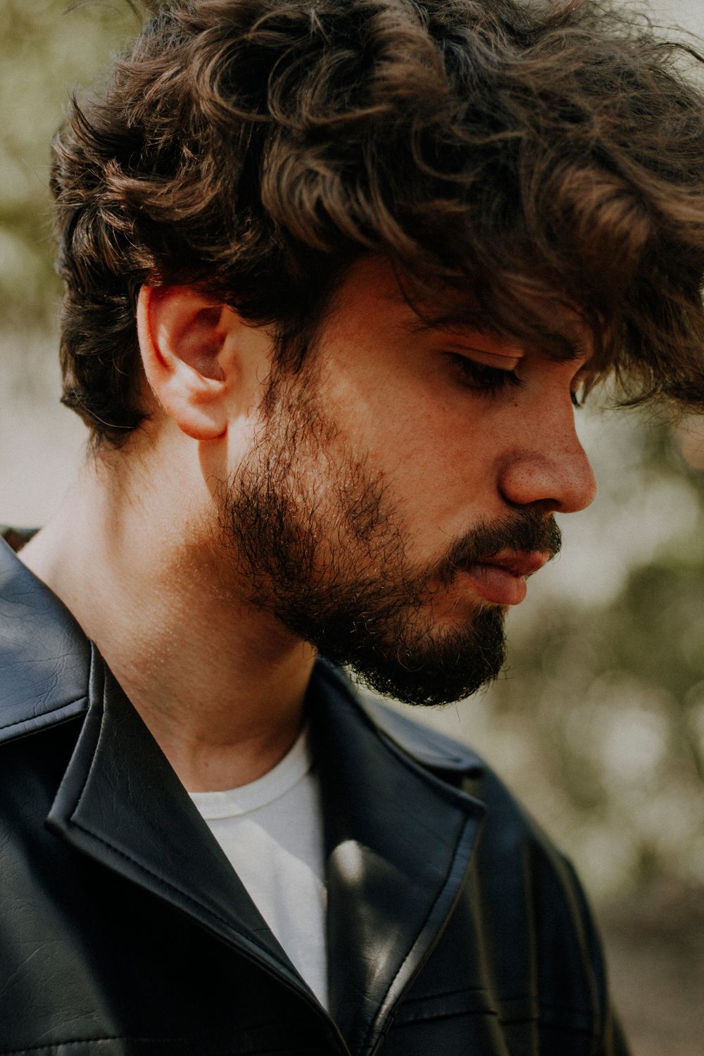 side profile of bearded man with wavy medium hair