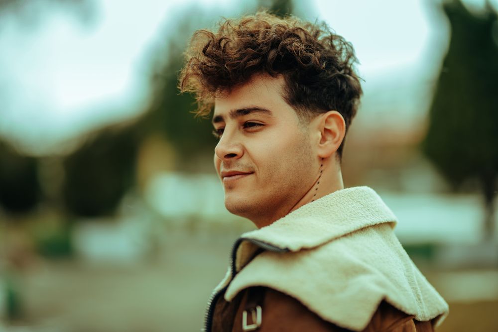 man with short wavy fringe and tapered fade