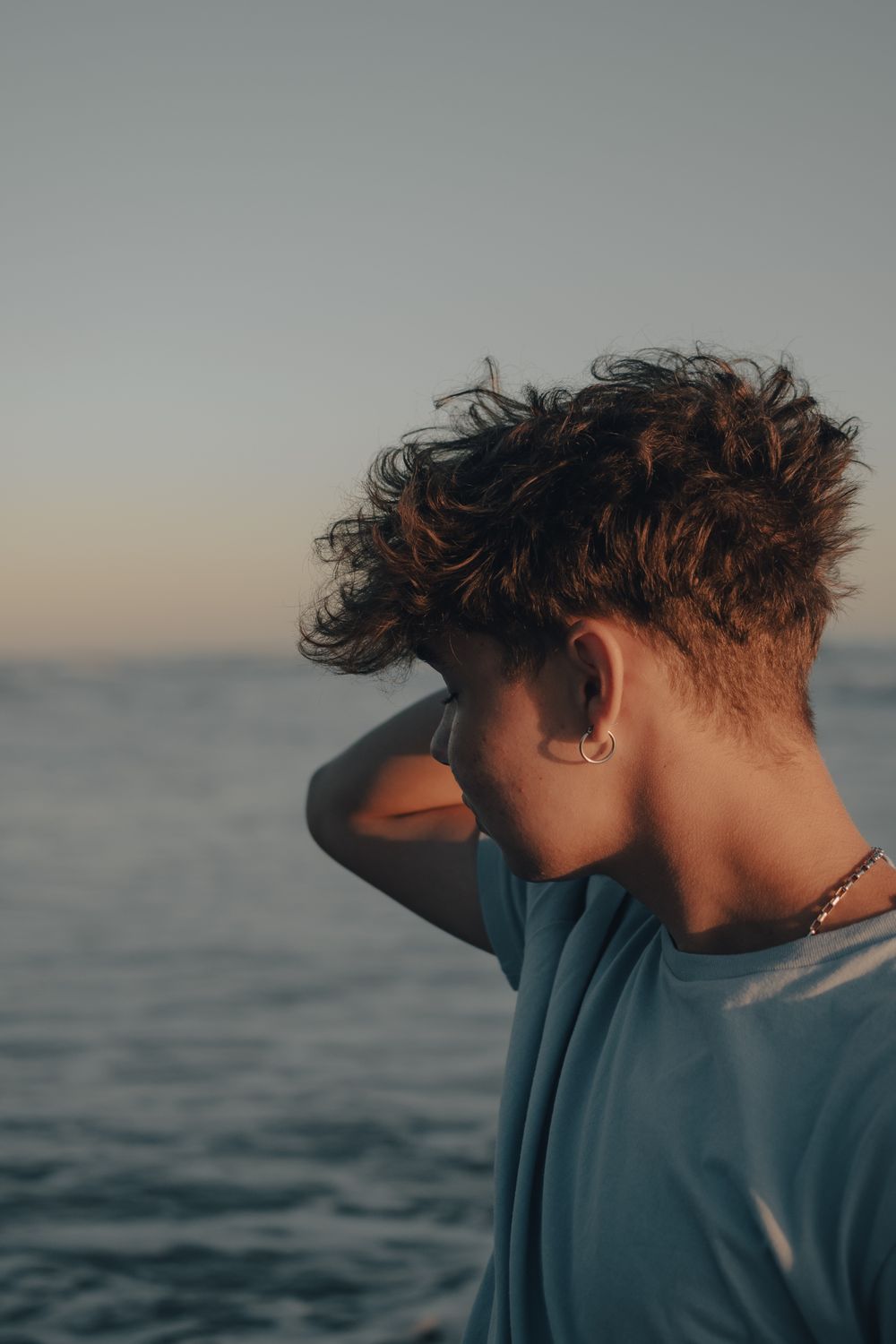 side profile of man with short wavy hair and a temple taper